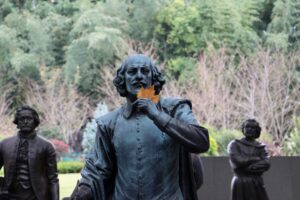 A statue of William Shakespeare holding an autumn leaf.